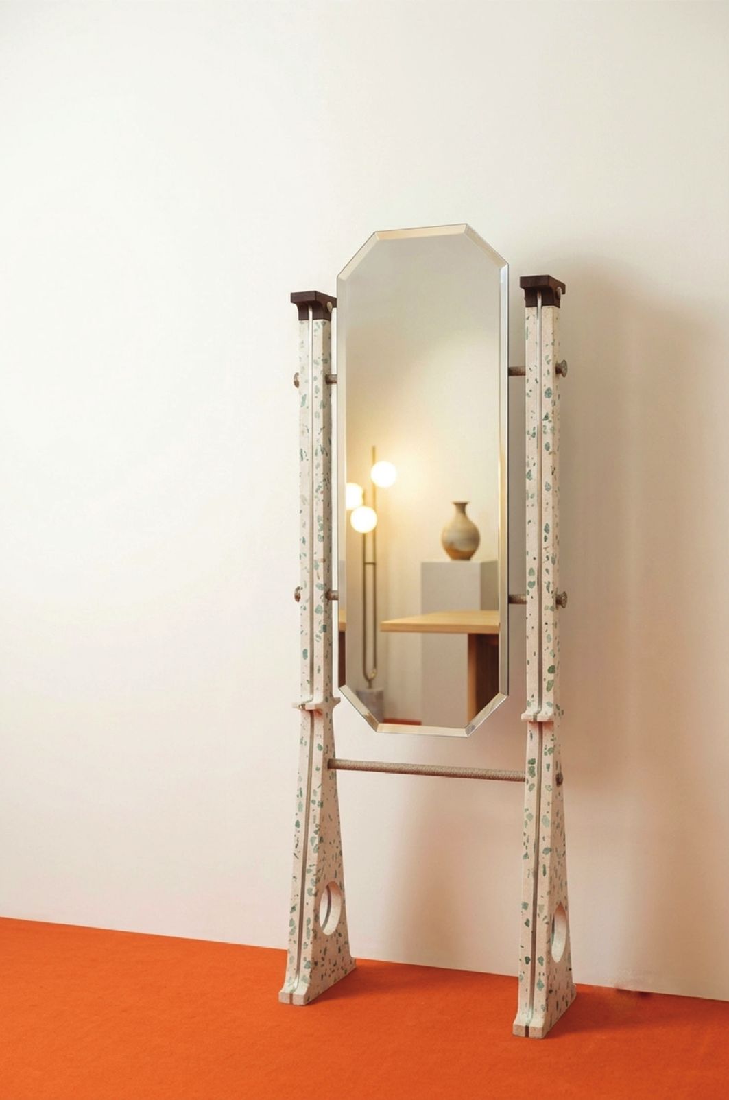 Eye Candy freestanding mirror: an octagonal bevelled mirror held between two tapering terrazzo posts flecked with green amazonite